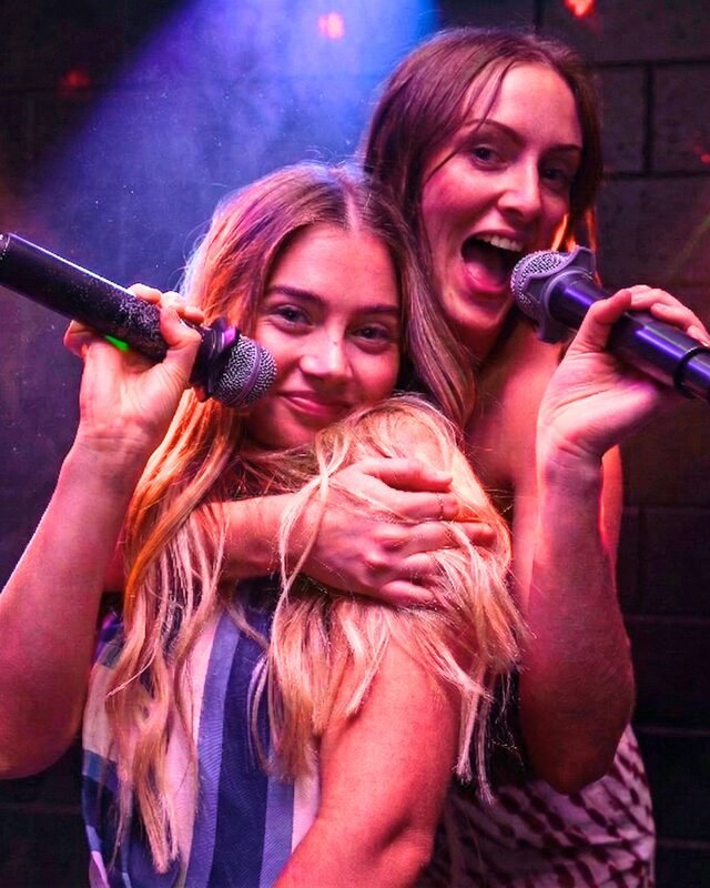 Two friends singing karaoke together at Spinners Bar and Bowl Maroochydore
