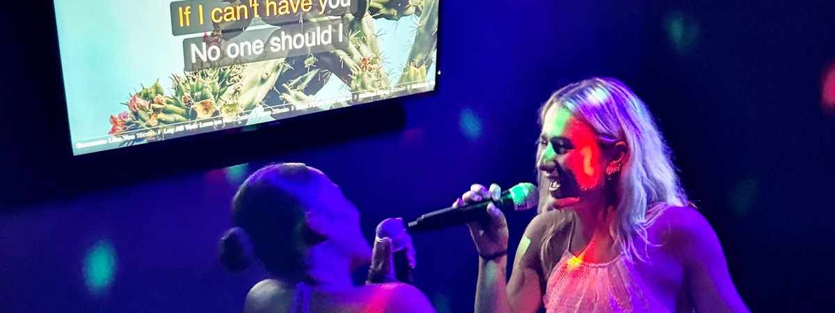 Duo singing karaoke with lyrics on screen at Spinners Bar & Bowl Maroochydore